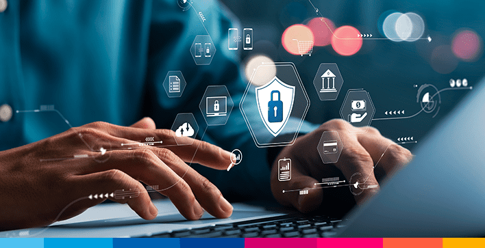 Mani su una tastiera con icone di sicurezza e protezione dei dati