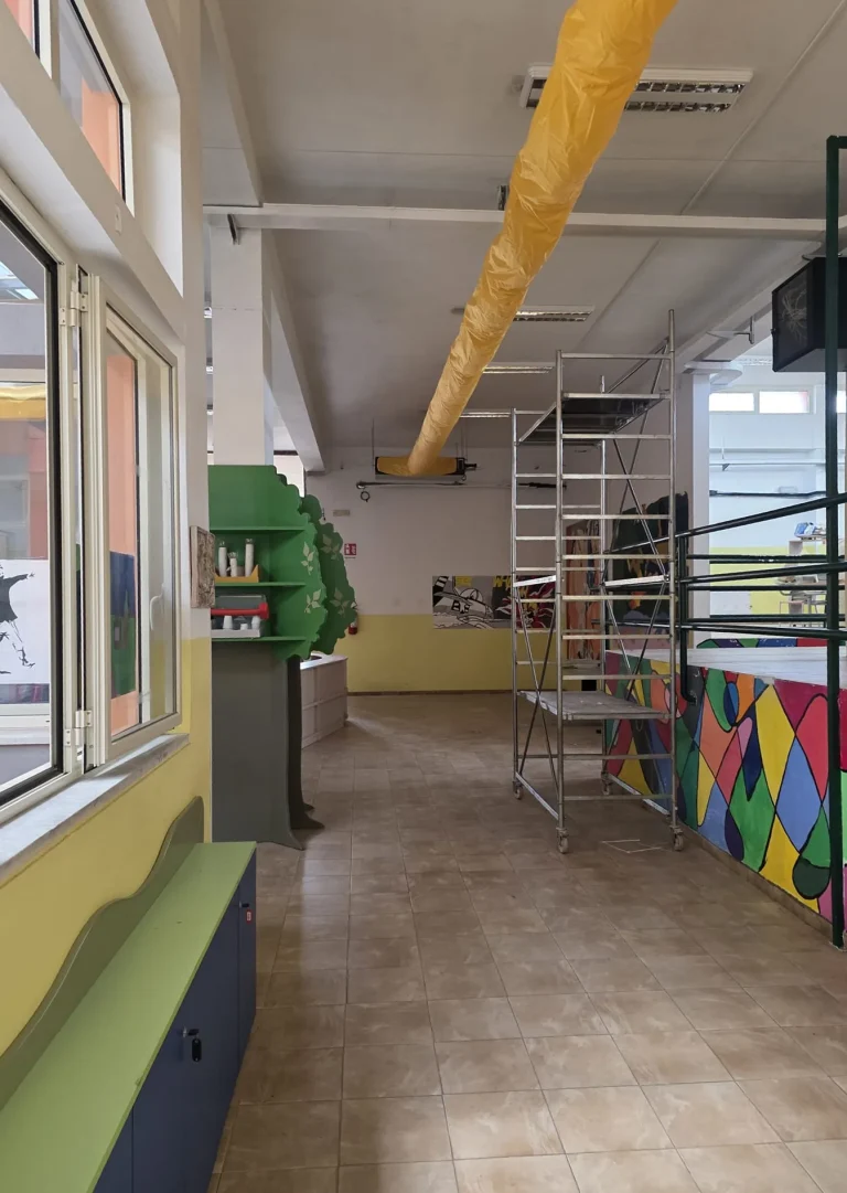 Installazione del canale tessile con trabattello nel cantiere di climatizzazione della scuola