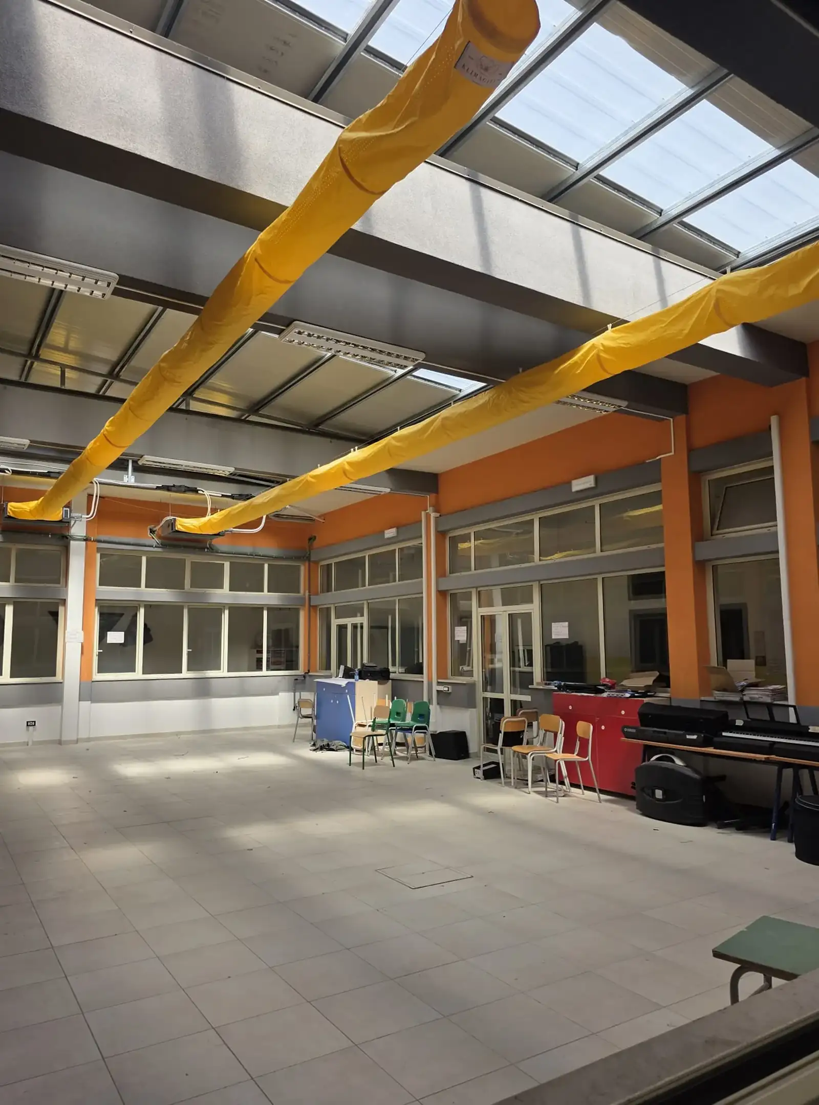 Canali e diffusori tessili microforati installati nell'atrio della scuola Brugnano