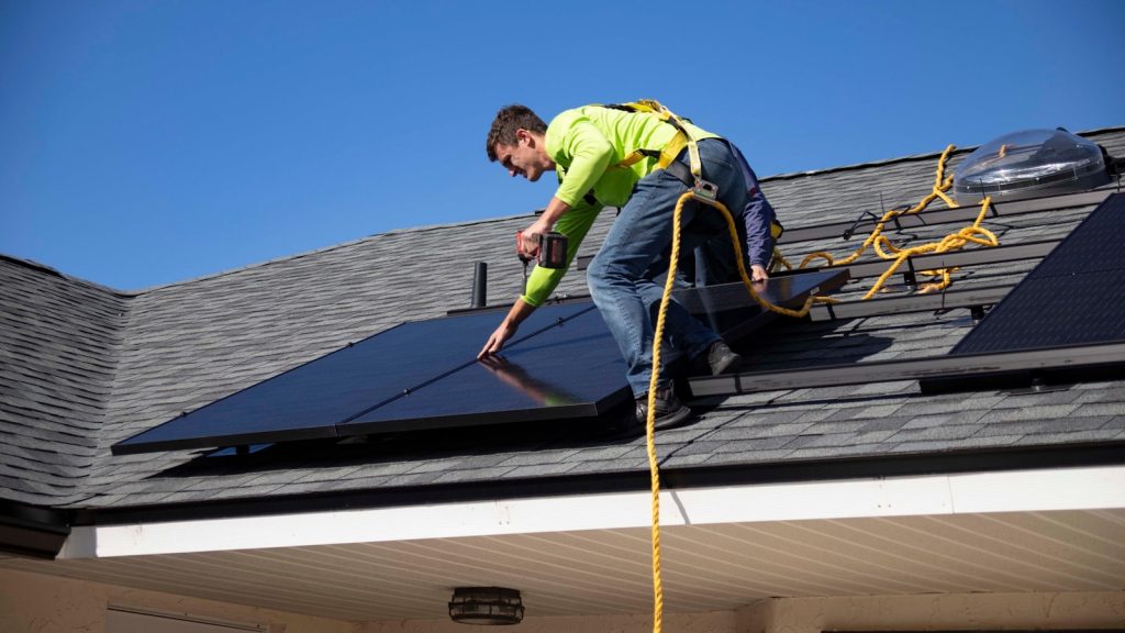 Installatore al lavoro su un impianto fotovoltaico sul tetto