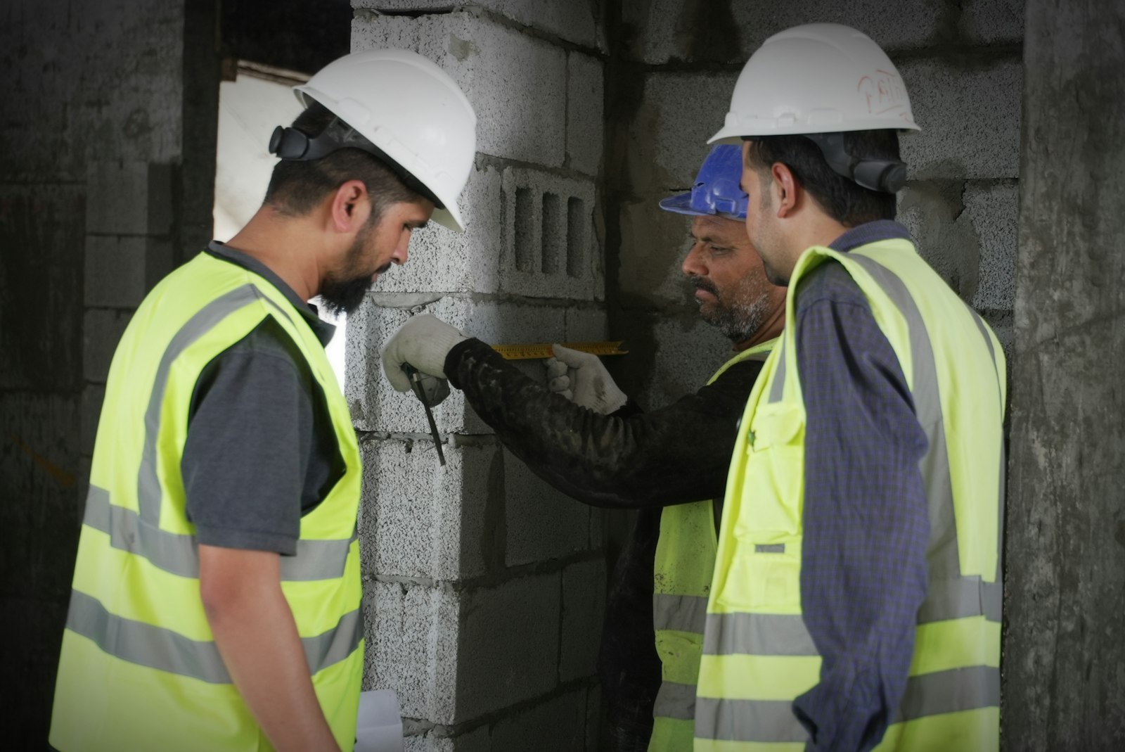 Tecnici con dispositivi di protezione durante un rilievo in cantiere