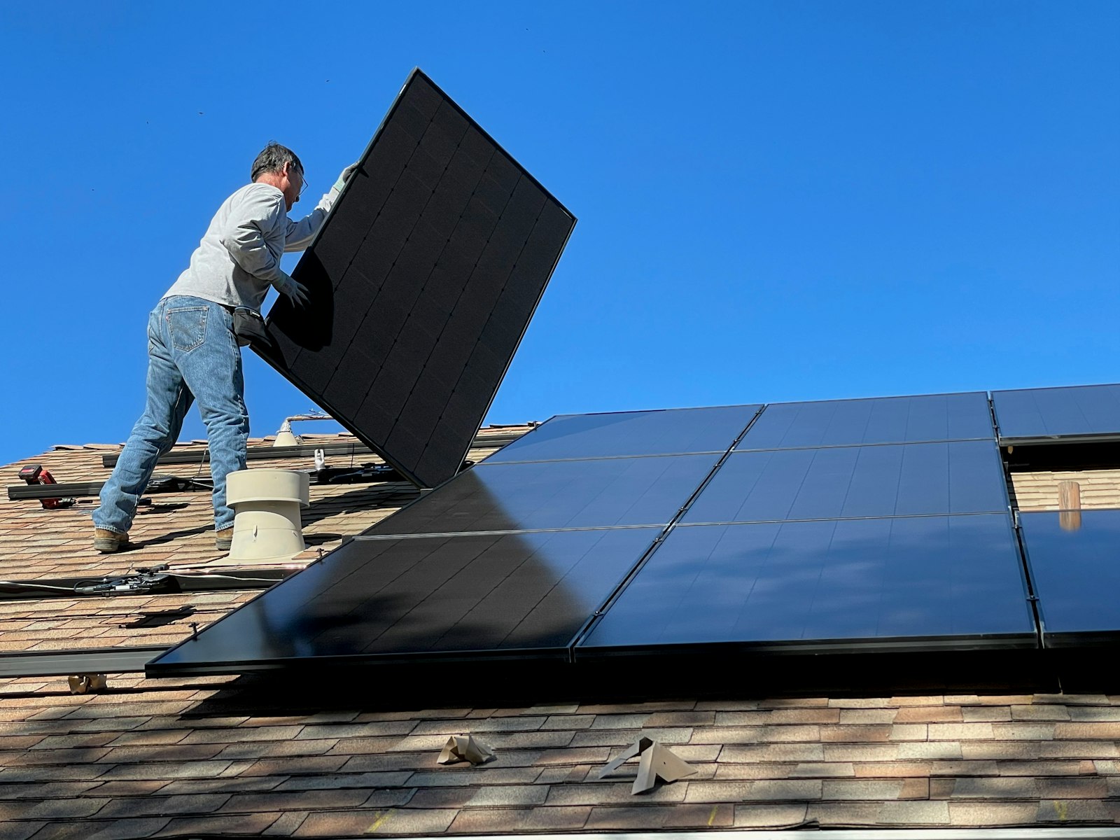 Installatore che posa un modulo fotovoltaico sul tetto