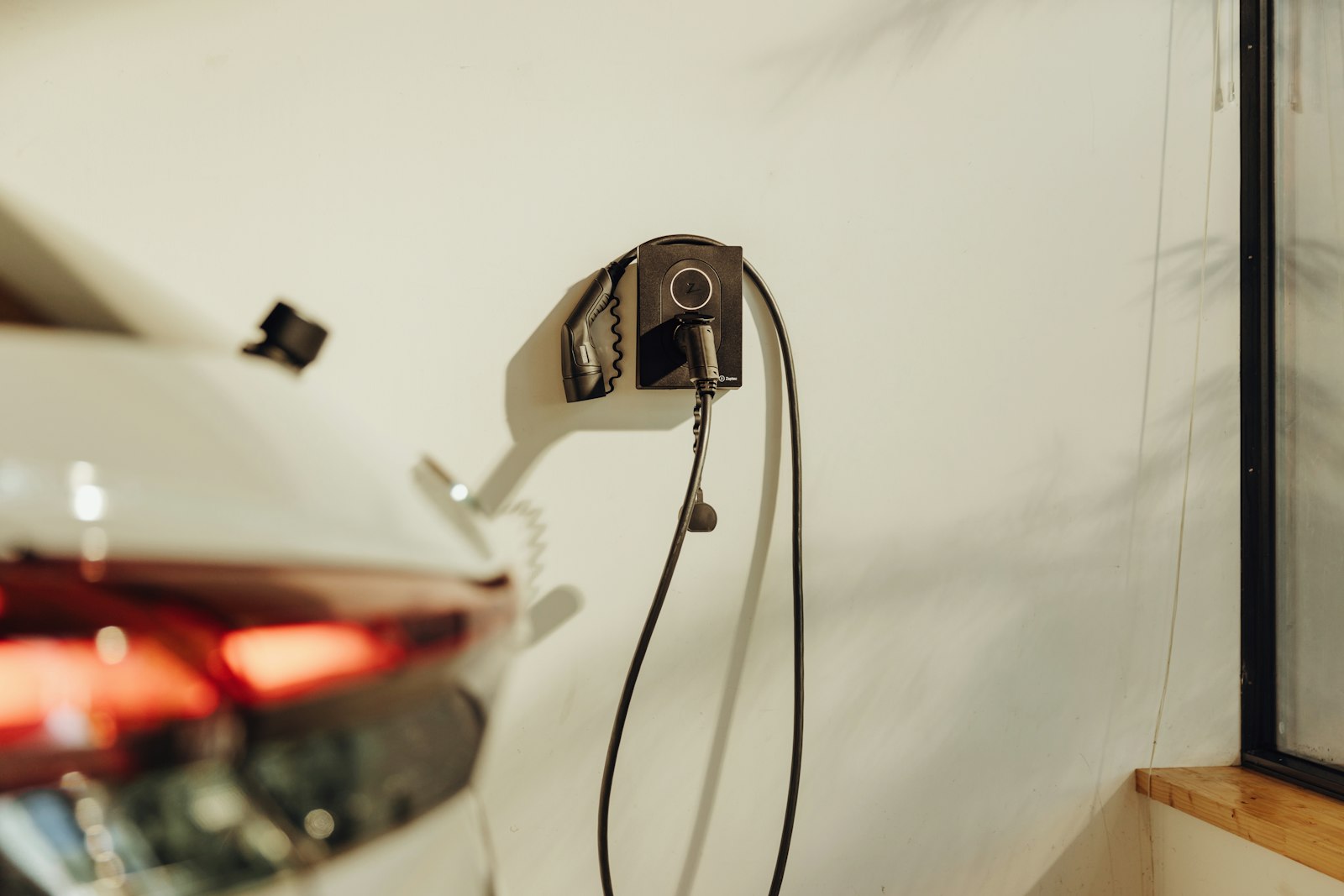 Auto elettrica collegata alla wallbox in un garage di casa