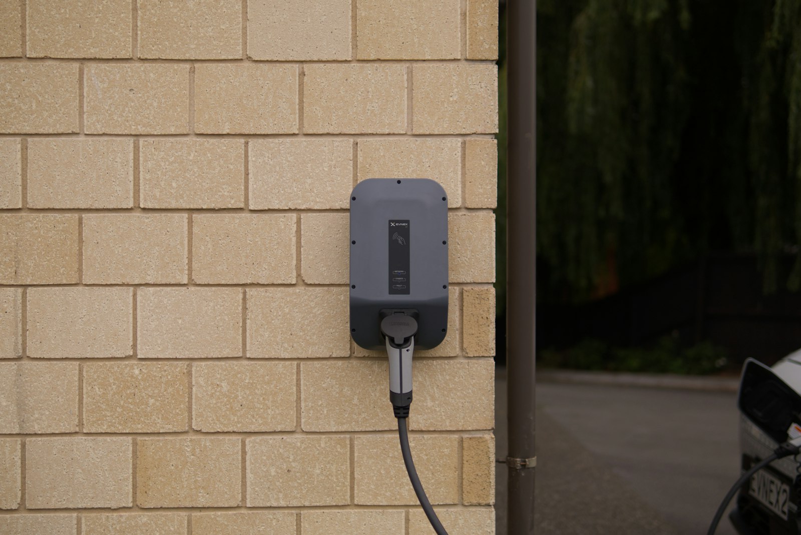Wallbox installata a parete con il cavo di ricarica collegato