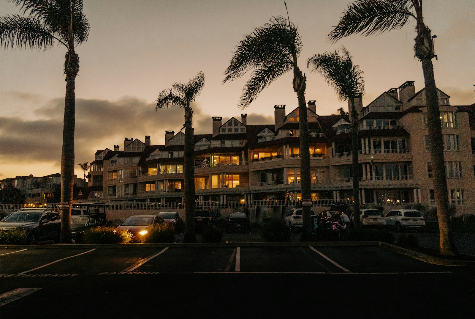 Condominio con palme e parcheggio al tramonto