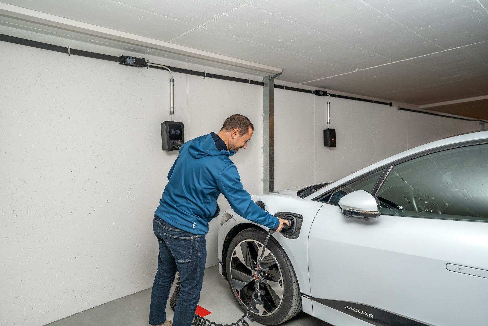 Ricarica di un'auto elettrica in un garage con più wallbox a parete